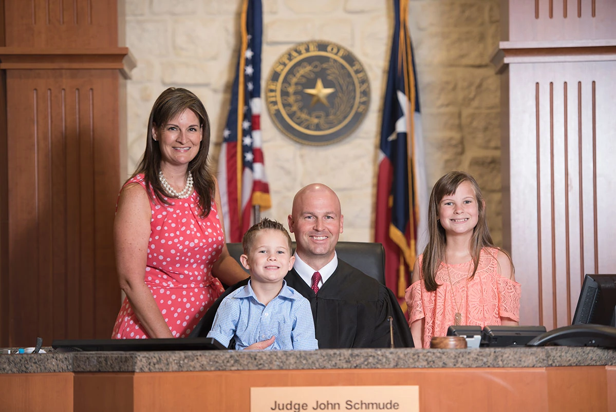 Judge John Schmude with his family at the bench of the 247th Family District Court